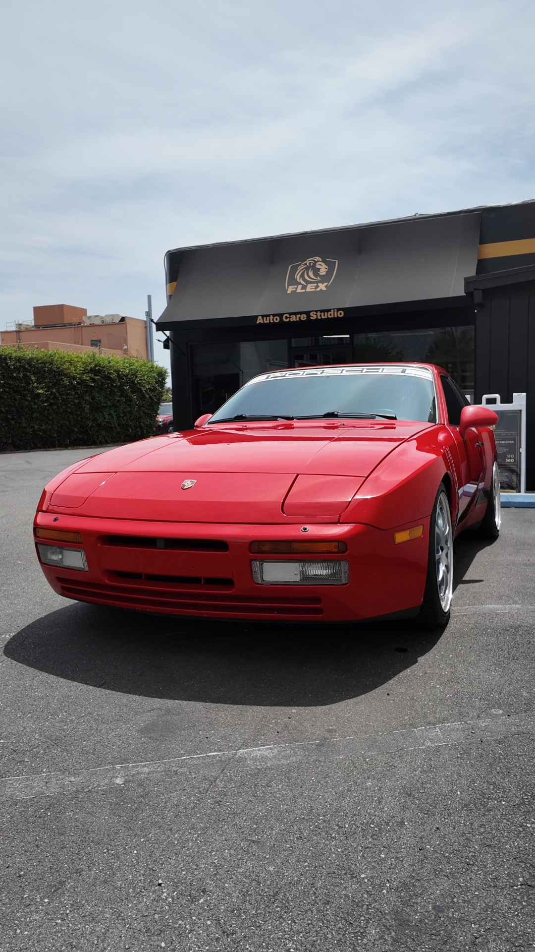 Red Porsche 944 Turbo front three-quarter outside the Flex Auto Care Studio storefront in Pasadena after window tinting
