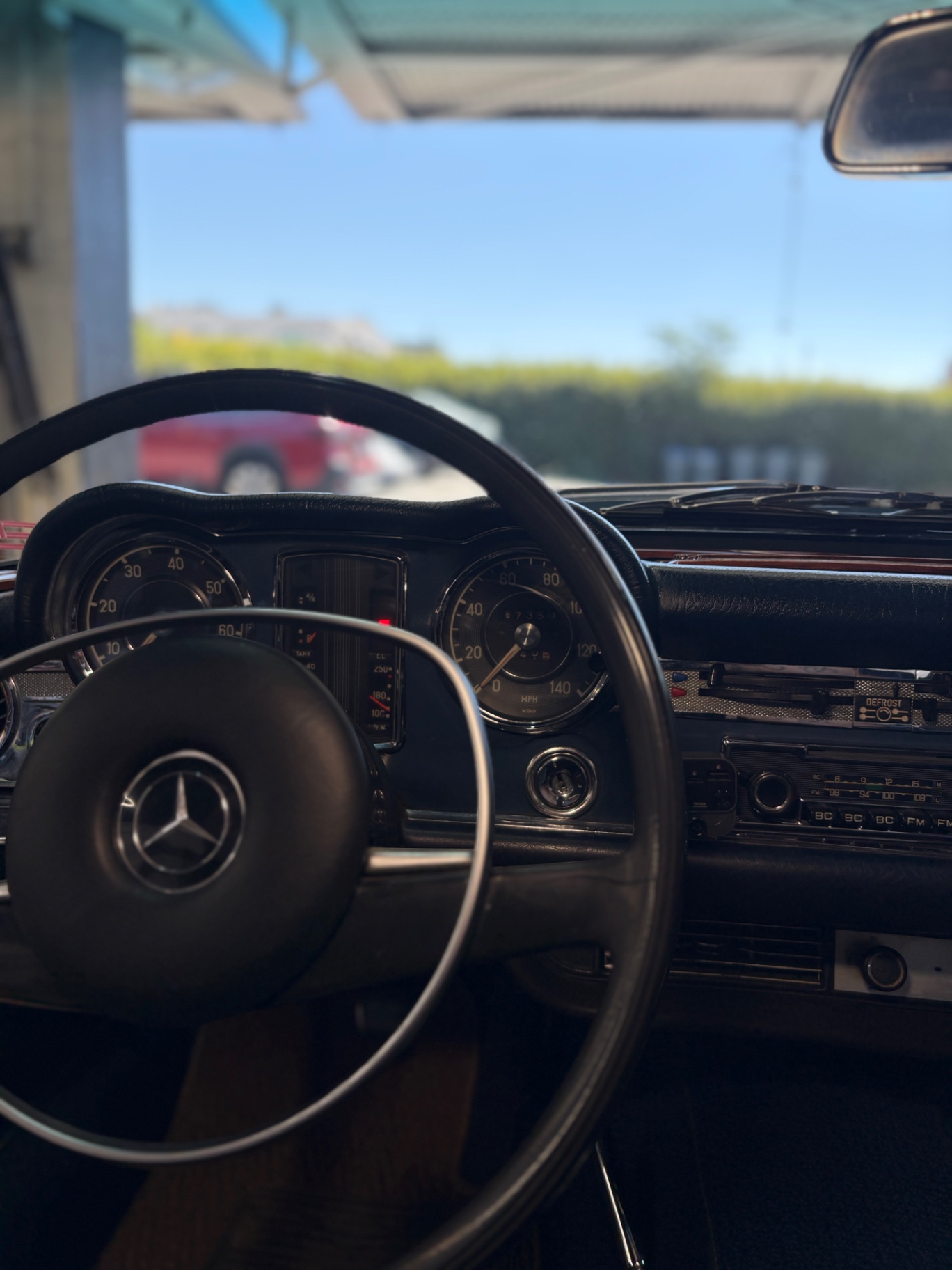 Mercedes-Benz 280SL gauge cluster and steering wheel detail in natural light