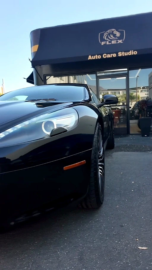 Aston Martin front fender, wheel and headlight detail with mirror-gloss finish outside the Flex Auto Care Studio